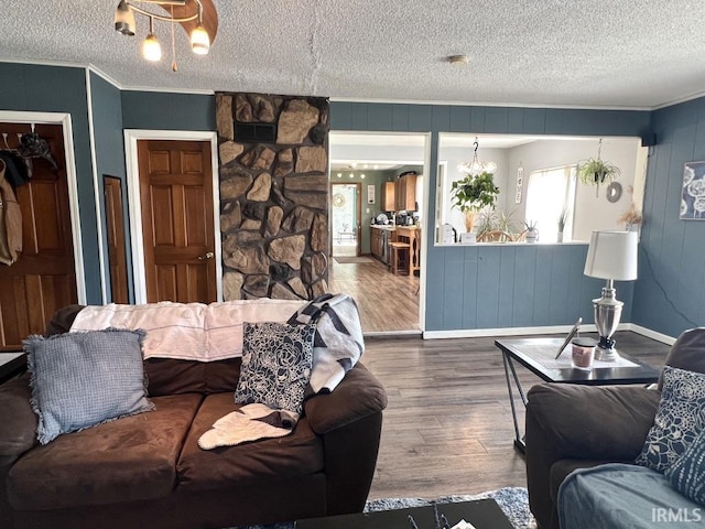 living area with a textured ceiling, crown molding, and wood finished floors