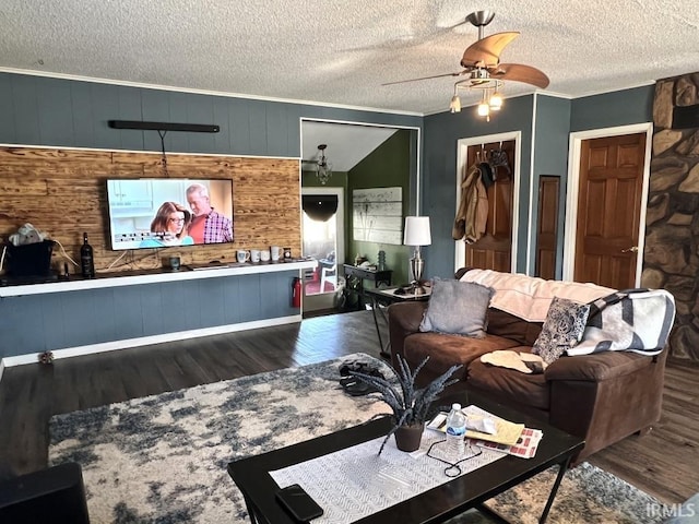 living area featuring ceiling fan, a textured ceiling, dark wood finished floors, and crown molding