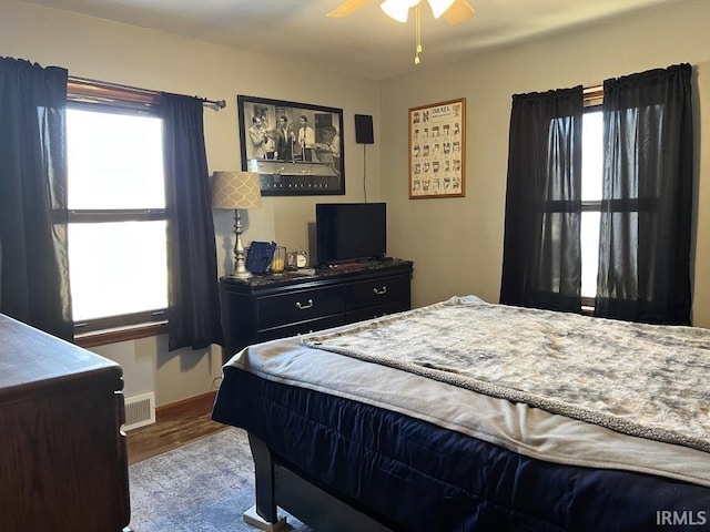 bedroom with multiple windows, visible vents, and wood finished floors