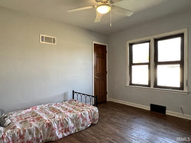 bedroom with dark wood-style flooring, visible vents, and baseboards