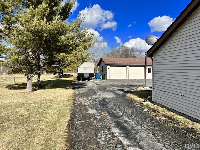 view of property exterior with a detached garage and an outdoor structure