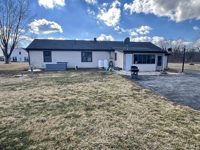 rear view of house with central air condition unit, a patio area, and a lawn