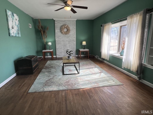 living room featuring ceiling fan, baseboards, and wood finished floors