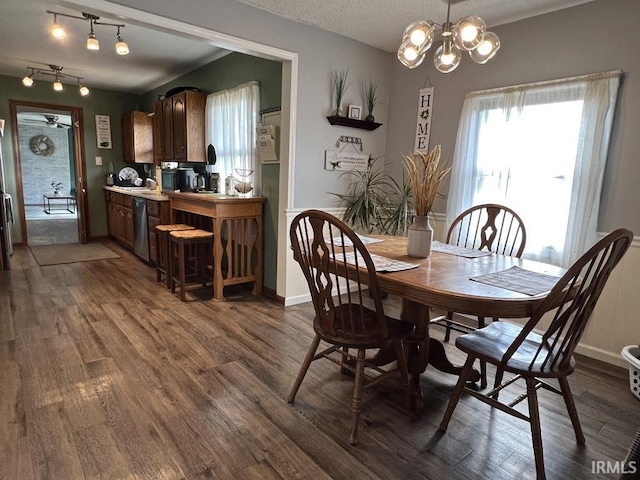 dining space featuring a chandelier, a textured ceiling, dark wood finished floors, and baseboards