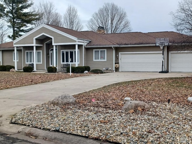 ranch-style home with a garage, a chimney, concrete driveway, and roof with shingles