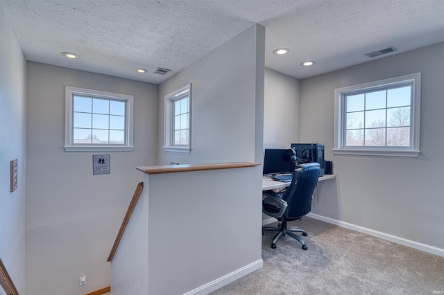 carpeted office featuring baseboards, visible vents, a textured ceiling, and recessed lighting