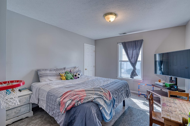 carpeted bedroom with baseboards, visible vents, and a textured ceiling