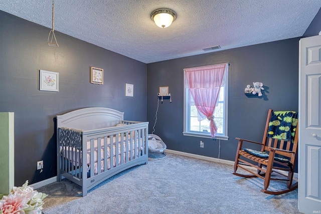 carpeted bedroom with a nursery area, visible vents, a textured ceiling, and baseboards