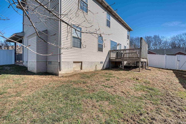 back of house featuring a yard, crawl space, a gate, fence, and a wooden deck