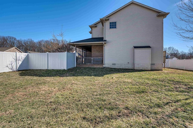 rear view of house featuring crawl space, a fenced backyard, and a lawn