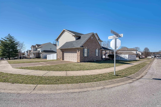 view of side of property with a garage, concrete driveway, roof with shingles, a yard, and brick siding