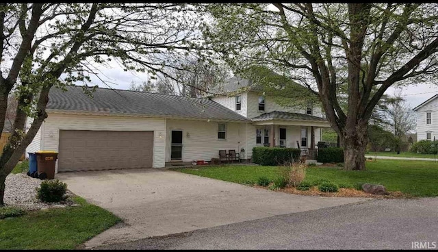 view of front of property with an attached garage, driveway, and a front lawn