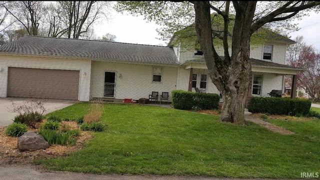 view of front of property featuring a garage, driveway, and a front lawn