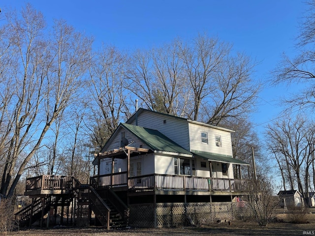 rear view of house featuring stairs, metal roof, and a deck