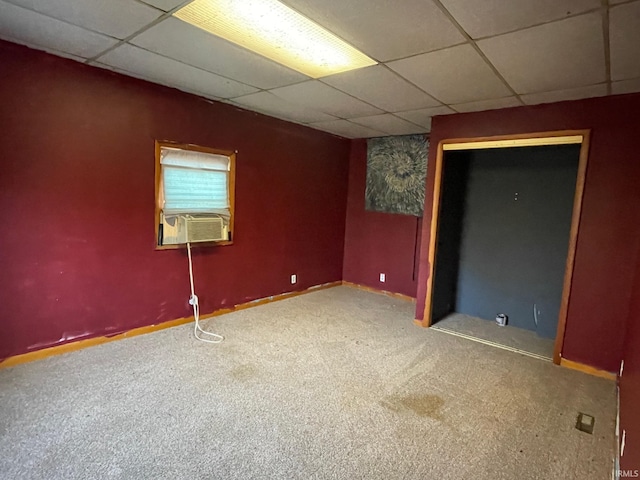 empty room featuring carpet, cooling unit, a paneled ceiling, and baseboards