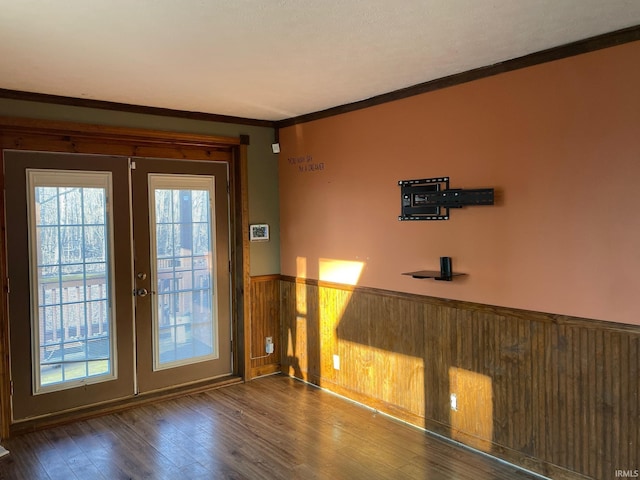 entryway featuring a wainscoted wall, french doors, wood finished floors, and a healthy amount of sunlight