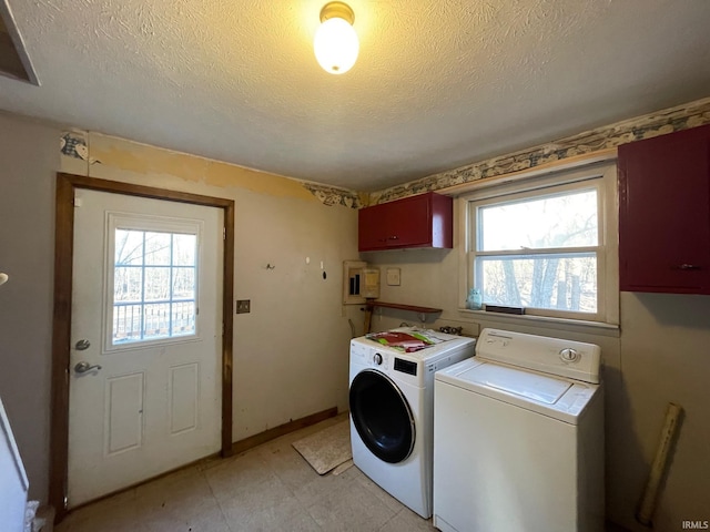 laundry area with baseboards, cabinet space, washer and clothes dryer, and a textured ceiling