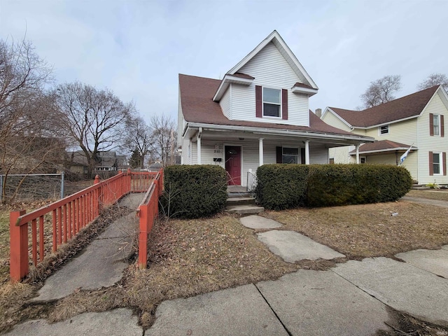 view of front of property with a porch and fence