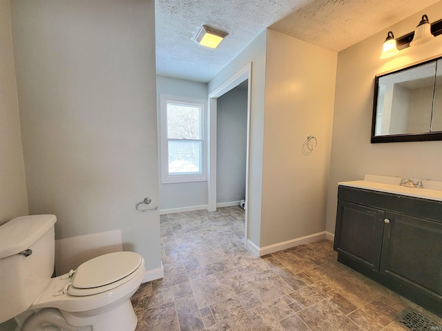 bathroom featuring visible vents, toilet, a textured ceiling, and baseboards