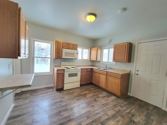 kitchen with white appliances, baseboards, dark wood-style floors, light countertops, and a sink