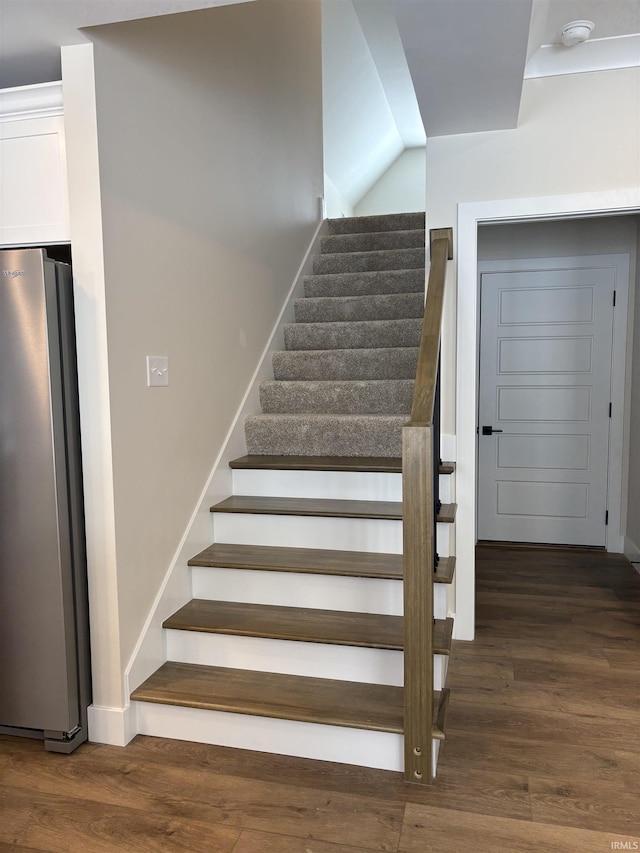 stairway with baseboards and wood finished floors