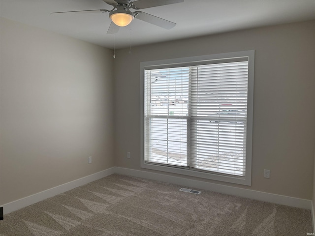 unfurnished room featuring carpet, visible vents, plenty of natural light, and baseboards