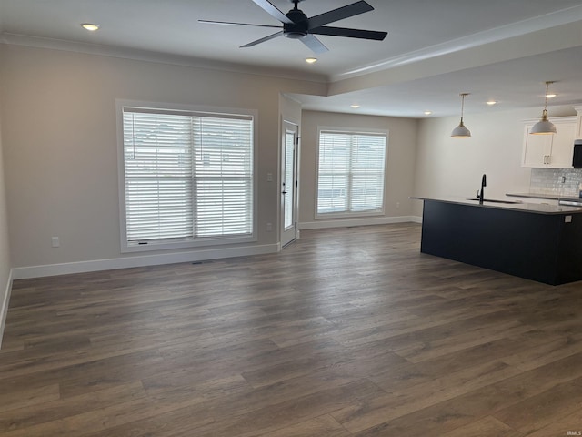 living area featuring recessed lighting, baseboards, dark wood-type flooring, and ornamental molding