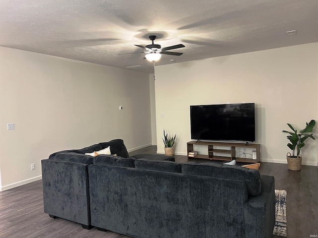 living area with baseboards, a textured ceiling, a ceiling fan, and dark wood-style flooring