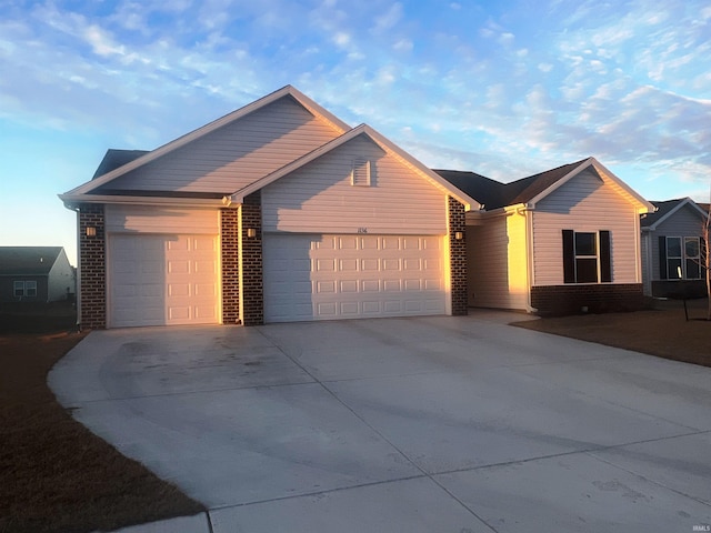 ranch-style house with a garage, driveway, and brick siding