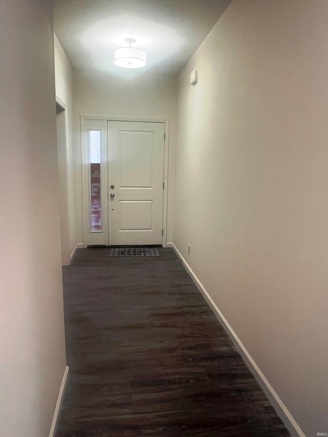 interior space featuring dark wood-style flooring and baseboards