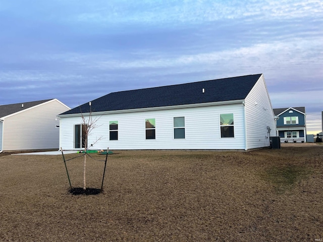 rear view of property featuring a yard and central AC unit