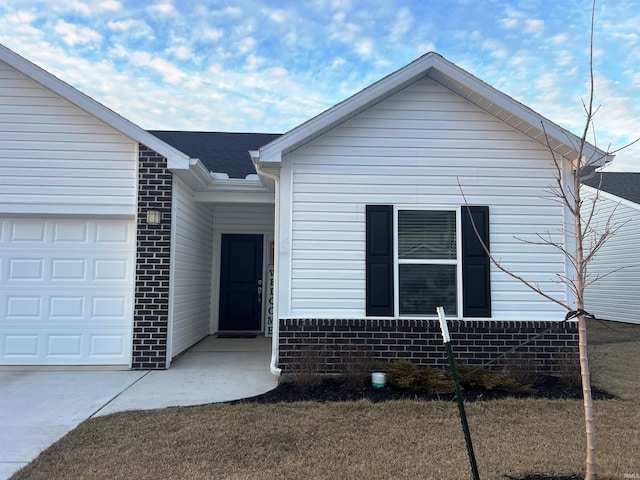 view of front of home featuring a shingled roof, brick siding, and an attached garage