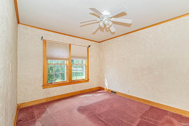 carpeted spare room with baseboards, a ceiling fan, visible vents, and crown molding