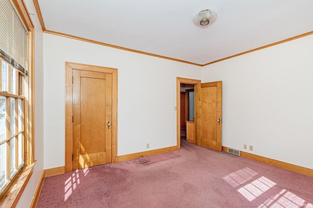 unfurnished room featuring ornamental molding, carpet flooring, visible vents, and baseboards