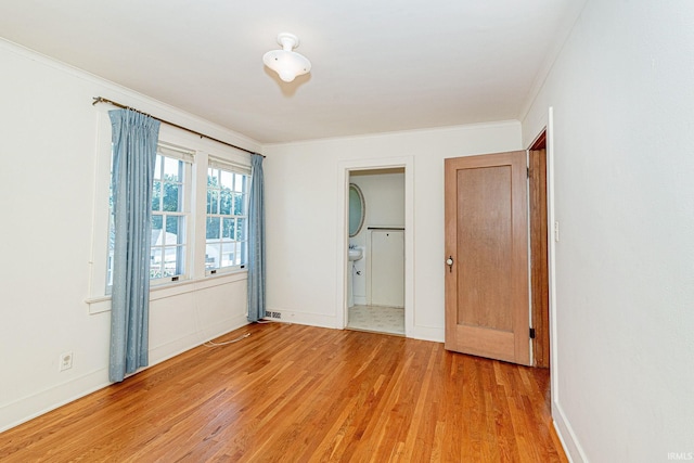 unfurnished room featuring light wood-type flooring, baseboards, and ornamental molding