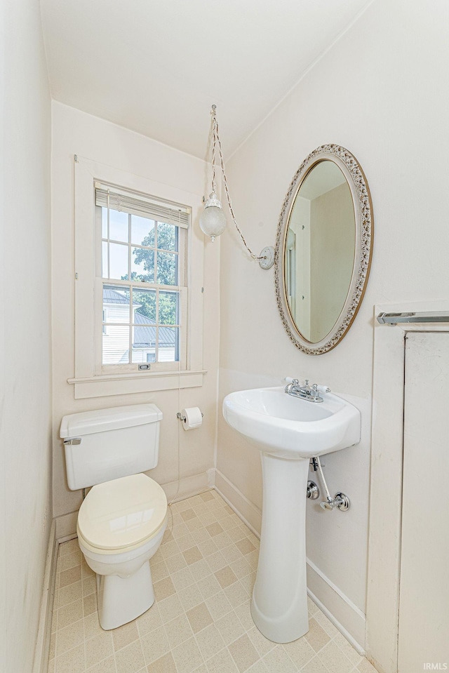 bathroom featuring toilet and baseboards