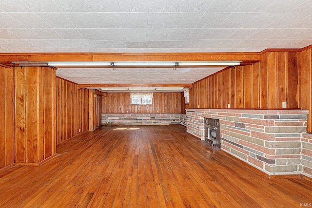 unfurnished living room featuring wood walls and wood-type flooring