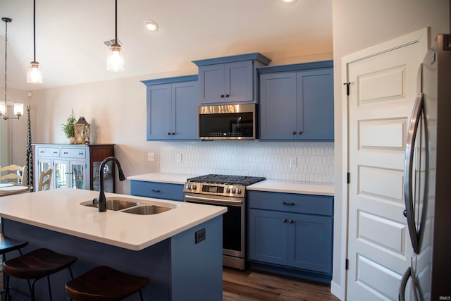 kitchen with a breakfast bar, blue cabinetry, stainless steel appliances, and a sink