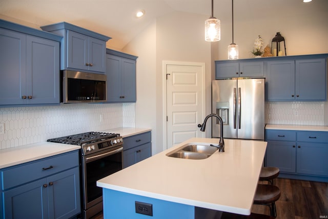 kitchen featuring stainless steel appliances, blue cabinets, a sink, and a kitchen bar