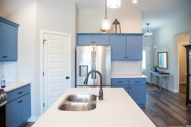 kitchen with stainless steel appliances, light countertops, blue cabinets, and a sink