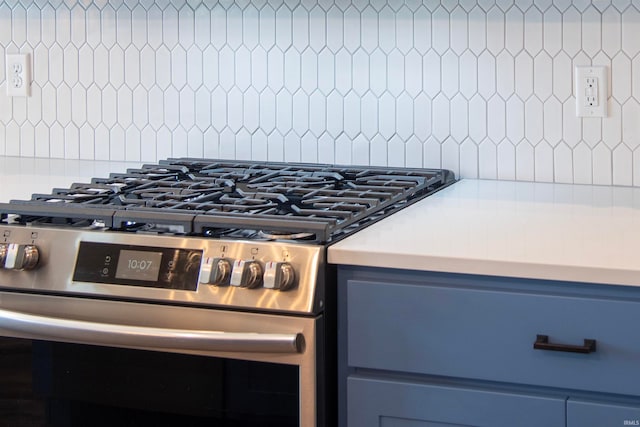 details featuring blue cabinetry, stainless steel gas range oven, and light countertops