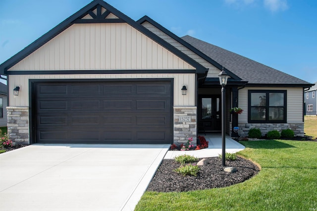 view of front of home with a garage, a shingled roof, driveway, stone siding, and a front lawn