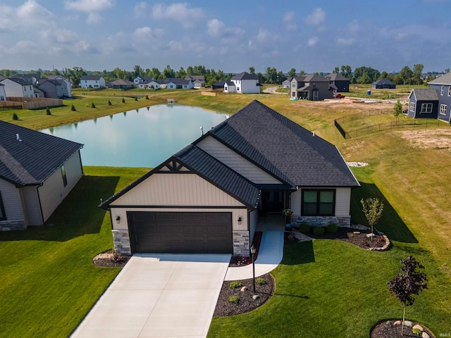 view of front of home featuring concrete driveway, stone siding, a residential view, an attached garage, and a water view