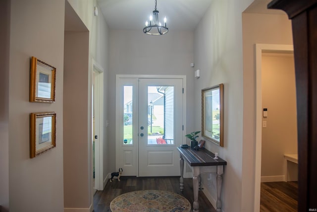 foyer entrance featuring baseboards, a chandelier, and wood finished floors