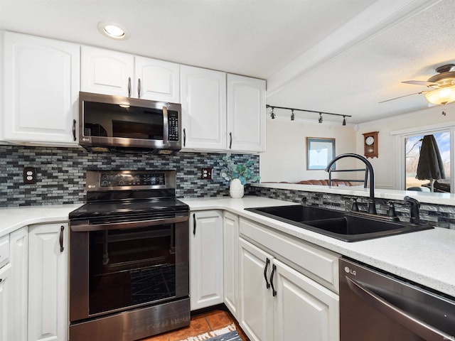 kitchen featuring appliances with stainless steel finishes, backsplash, a sink, and white cabinets