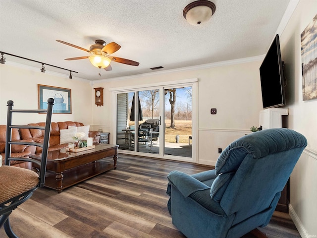 living area with visible vents, ceiling fan, dark wood-style flooring, crown molding, and a textured ceiling