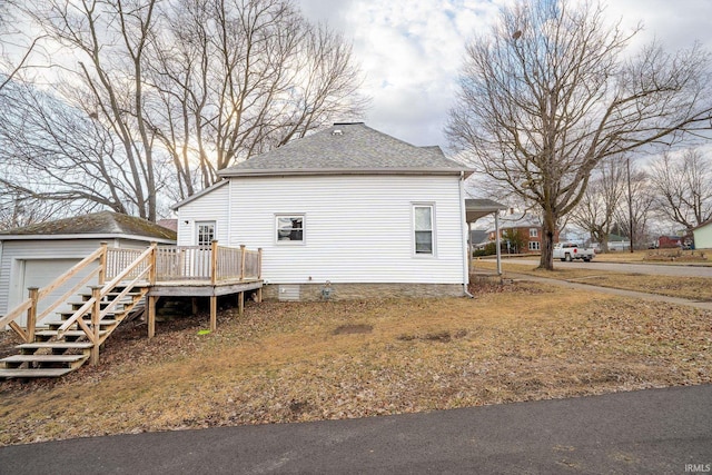 view of side of property with an outbuilding, a deck, and roof with shingles