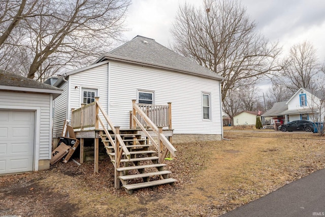 view of side of property featuring a shingled roof and stairway