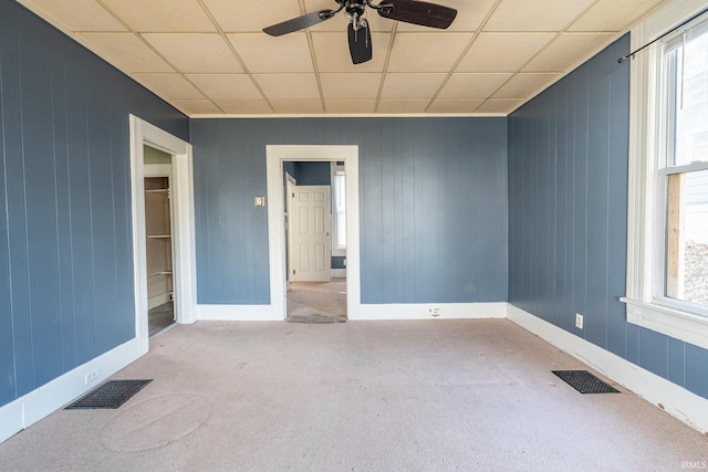 unfurnished room featuring carpet, a healthy amount of sunlight, and visible vents