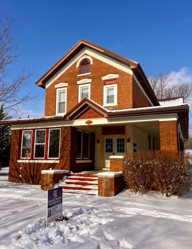 view of front facade featuring covered porch and brick siding